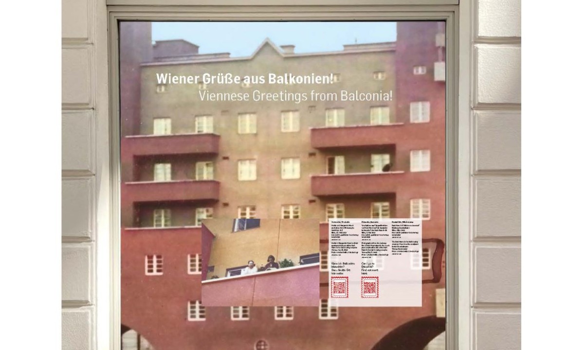 Window display at the Jewish Museum Vienna titled 'Wiener Grüße aus Balkonien!' with English subtitle 'Viennese Greetings from Balconia!' showing a photo of a residential building with balconies and a text panel with QR codes.