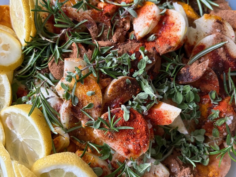 Shabbes chicken garnished with herbs and lemon