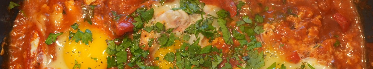 : Drei Spiegeleier mit gehackter Petersilie und Tomatensauce auf einem Teller.