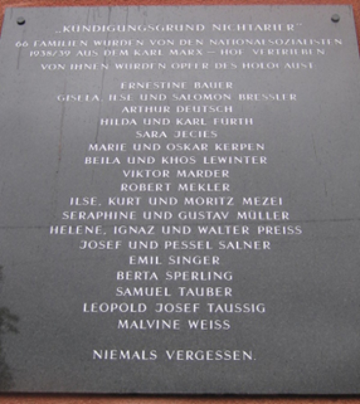: Memorial plaque listing names of victims of the Holocaust, including families and individuals, with the phrase 'Niemals vergessen' (Never forget) at the bottom.