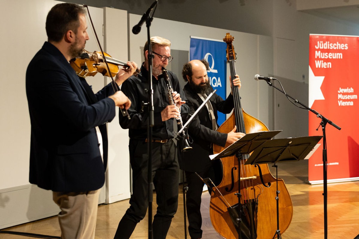 : Eine Band aus drei Personsn spielt musik auf verschiedenen Instrumenten