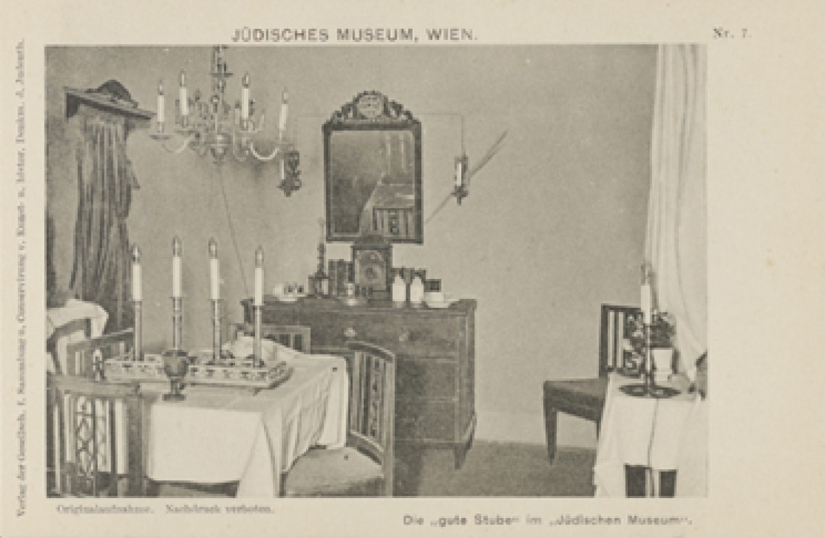 : Fotopostkarte eines historischen Raums, für den Schabbat hergerichtet und als Teil einer Museumsausstellung präsentiert.