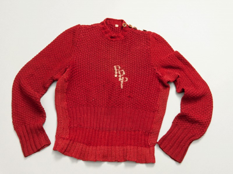 A red, knitted sweater with the initials “PPP”