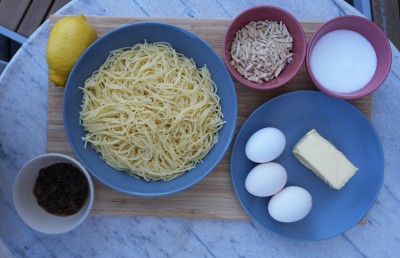 : Zutaten für Lokschenkigl auf einem Holzbrett angerichtet.